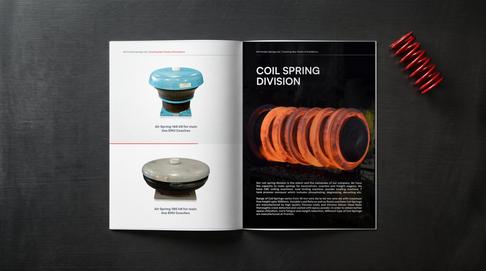 Frontier Springs brochure open on brushed steel beside a red coil spring